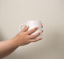 hand is holding a mug or glass on a white isolated background photo