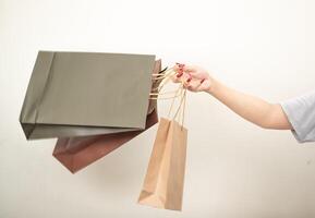 hand holding a shopping paper bag against a white isolated background photo