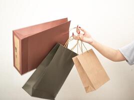 hand holding a shopping paper bag against a white isolated background photo