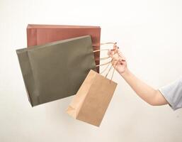 hand holding a shopping paper bag against a white isolated background photo