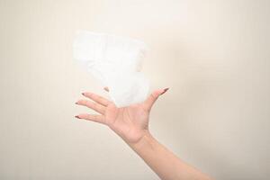 hand is holding a piece of tissue on a white isolated background photo