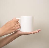 hand is holding a mug or glass on a white isolated background photo