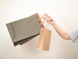 hand holding a shopping paper bag against a white isolated background photo