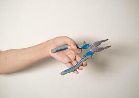 hand is holding a pliers on a white isolated background photo