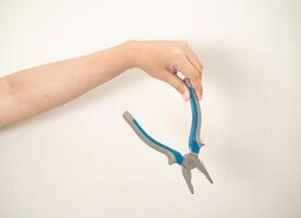 hand is holding a pliers on a white isolated background photo