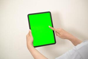 mano es participación un lengüeta con verde pantalla en un blanco aislado antecedentes foto