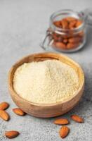 Fresh almond flour in a  bowl and almonds photo