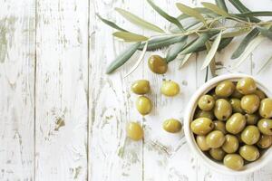 ai generado cuenco de verde aceitunas en un rústico blanco de madera mesa con aceituna ramas foto