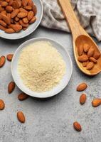 Fresh almond flour in a  bowl and almonds photo