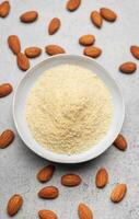 Fresh almond flour in a  bowl and almonds photo