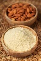 Fresh almond flour in a  bowl and almonds photo