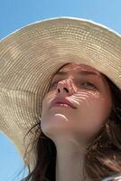 AI generated Young Woman Wearing a Straw Hat Against a Clear Blue Sky on a Sunny Day photo