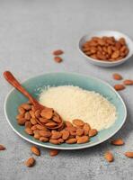 Fresh almond flour in a  bowl and almonds photo