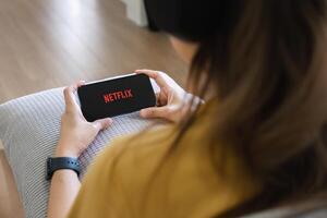 netflix logo en iphone 14 pantalla. netflix es un internacional líder suscripción Servicio para acecho televisión episodios y películas foto