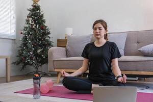 joven asiático deportivo aptitud mujer entrenador hacer práctica vídeo en línea formación yoga ordenador portátil en vivo habitación a hogar foto