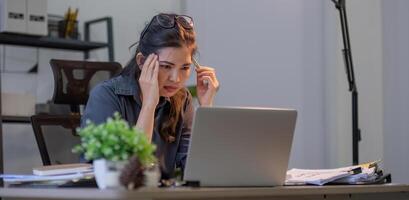 Puzzled confused asian woman thinking hard concerned about online problem solution looking at laptop screen, worried serious asian businesswoman focused on solving difficult work computer task photo