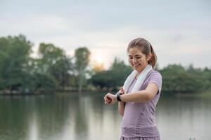 Young Asian woman takes care of her health by exercising. Stretch your legs in the park photo