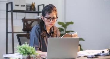 Puzzled confused asian woman thinking hard concerned about online problem solution looking at laptop screen, worried serious asian businesswoman focused on solving difficult work computer task photo