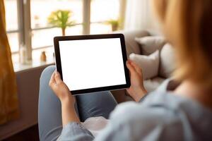 AI generated Woman sitting on sofa while holding white blank screen tablet at home photo