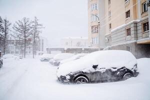 el coche es enterrado debajo un capa de nieve. pesado nevada en el ciudad. el equipo soportes debajo un ventisquero. Consecuencias de un invierno huracán. foto