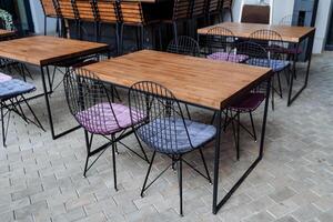 desván encimera soportes en el calle, diseñador mueble para un verano cafetería, un de madera mesa, un restaurante en el acera, comida en el calle, No gente. foto