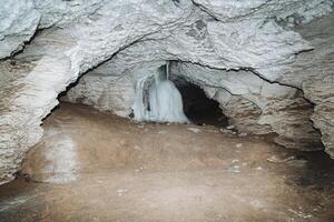 cueva karlamanskaya Rusia bashkortostán del Sur Urales, karst salón de el cueva es iluminado por el ligero de un linterna, hielo fluye abajo el muro, espeleología foto