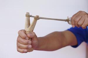 Close up hands hold wooden slingshot for playing shooting game. Concept , Thai traditional weapon that use to shoot birds, fish , for fight game or other purposes. photo