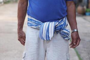 Close up Thai loincloth tied on waist of senior man. Concept, local man fashion in Thailand. Traditional lifestyle. Loincloth is a multi-purpose cloth that Thai people have used since ancient times. photo