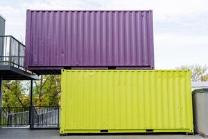 Two shipping containers stand on top of each other in a city park, an urban landscape, a metal construction site, colored iron boxes, a relief profile. photo