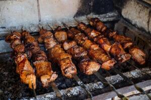 Barbecue on coals, meat fried on skewers, beef under marinade, delicious dish of Caucasian cuisine, summer treats for guests, pork kebab photo