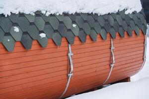 The side wall of the wooden bath barrel. Metal fastening of wooden wall. Protective coating for the roof roof ruberoid. photo