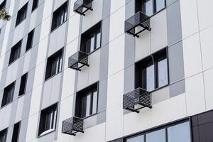 ver de el fachada de el edificio con ventanas Departamento edificio con aire acondicionamiento en cada departamento. alojamiento en el ciudad centro. perspectiva, suave líneas de el edificio foto