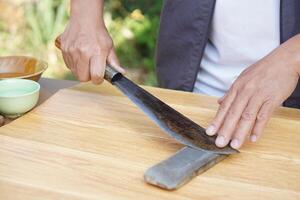 Closeup man hands sharpen knife on whetstone sharpener or grindstone. Concept, maintenance tools for cooking, make knife sharp ,not dull for long live using. Original style. photo