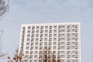 asombroso ver desde lejos de un de muchos pisos blanco edificio. residencial complejo para cómodo vivienda.apartamento creciente alto arriba a el cielo foto