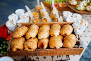 Fresco pasteles en un café tienda. salchicha en masa crujiente bollo con relleno. sano meriendas recién horneado croissants en un de madera cesta. cariño y crujiente postres foto