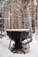 Bath tub for swimming in the open air. Hardening in winter.a container with hot water under source of fire that heats the temperature to 38-40 degrees photo