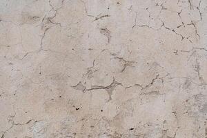 An old shabby wall with cracks. Peeling plaster. Street walls of the old building. Renovation of living quarters. Textured surface, abstract drawing photo