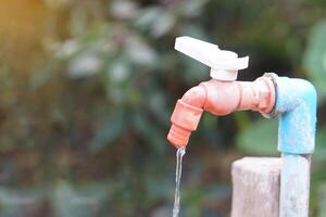 Old water faucet with dripping. Concept. Save water for environment. Turn off tap or faucet  before leaving. Don't waste water by let it dripping or leaking. photo