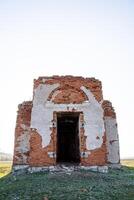 The entrance to the old building, the ancient temple is destroyed, the front door is missing, the roof was demolished, the church ruins against the sky, the abandoned building. photo