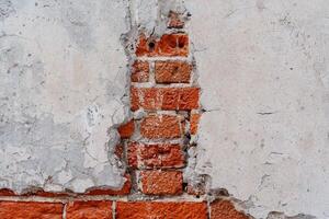 un cerca Disparo de el pared. el ladrillo pared es cubierto con un grueso capa de cemento. mala calidad construcción trabajar. rojo ladrillo pared foto