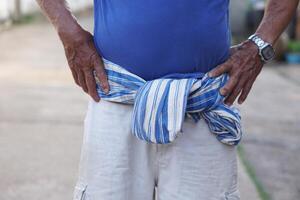 Close up Thai loincloth tied on waist of senior man. Concept, local man fashion in Thailand. Traditional lifestyle. Loincloth is a multi-purpose cloth that Thai people have used since ancient times. photo