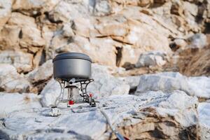 Aluminum pan stands on a gas burner, cooking on a hike, equipment for climbers in the mountains, cooking in nature, hiking photo