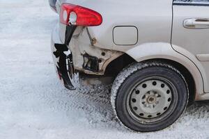 A car with a broken right wing at the rear. Accident on the road, The wheel of the car is unprotected. photo