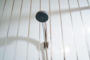 Metallic shower head in the bathroom. Regulation of temperature and water pressure in the bathroom and shower. Water procedures in the house. Bathing, taking a bath and going to the shower. photo