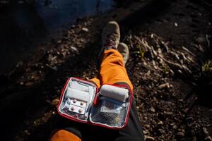 The first aid kit is open on your lap, the view from above on the kit of drugs for first aid, medicines are folded into a small bag, tablets, bandages. photo