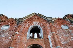 Brick old building, house destroyed by time, ghosts of war in the ruins of an old building, arch window on the second floor, temple broken, church ruins photo