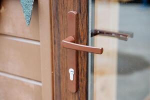 Door handle close-up, glass door entrance from the street, double-glazed front door, keyhole to close the door outside, clear glass photo