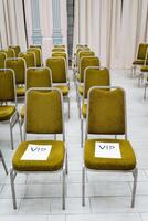 Green chairs stand in even rows. Ahead of the VIP seats. Conference hall, trainings in the classroom. photo