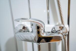 grifo en el baño. regulación de temperatura y agua presión en el baño y ducha. agua procedimientos en el casa. baños, tomando un bañera y yendo a el ducha. foto