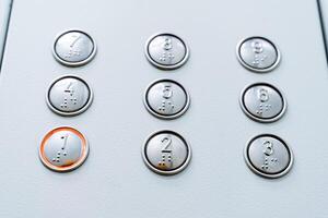 A close shot of burning elevator buttons. First floor. Call the elevator cabin. Minimalistic design of buttons photo